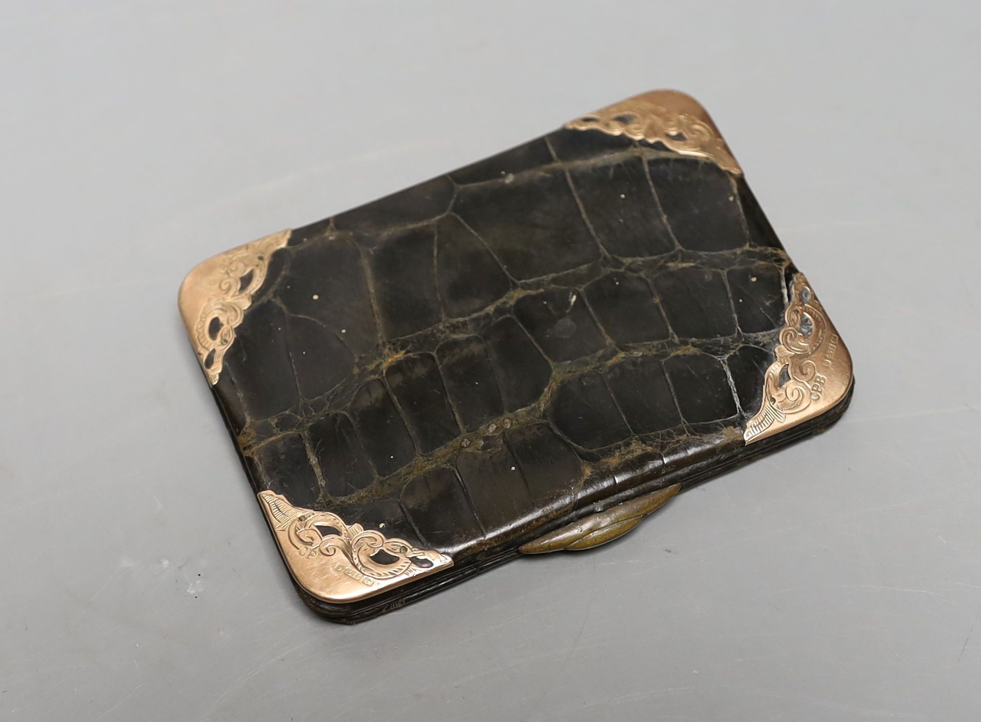 A late Victorian engraved silver sovereign case, a silver vesta case and an Edwardian 9ct gold mounted leather card purse.